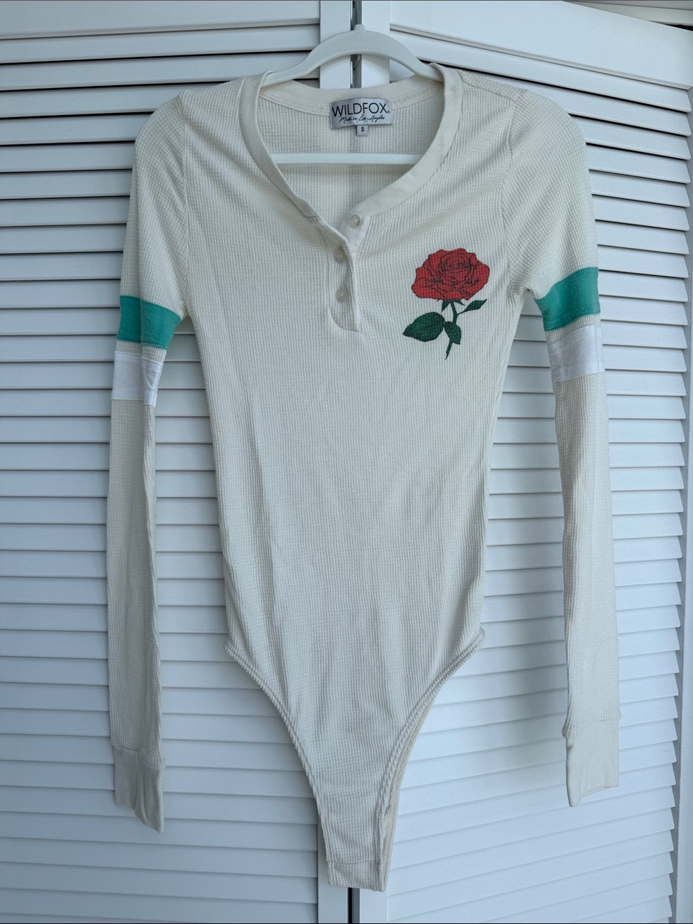 Wildfox Cream Henley Bodysuit with Red Rose Patch and Teal Sleeve Stripes